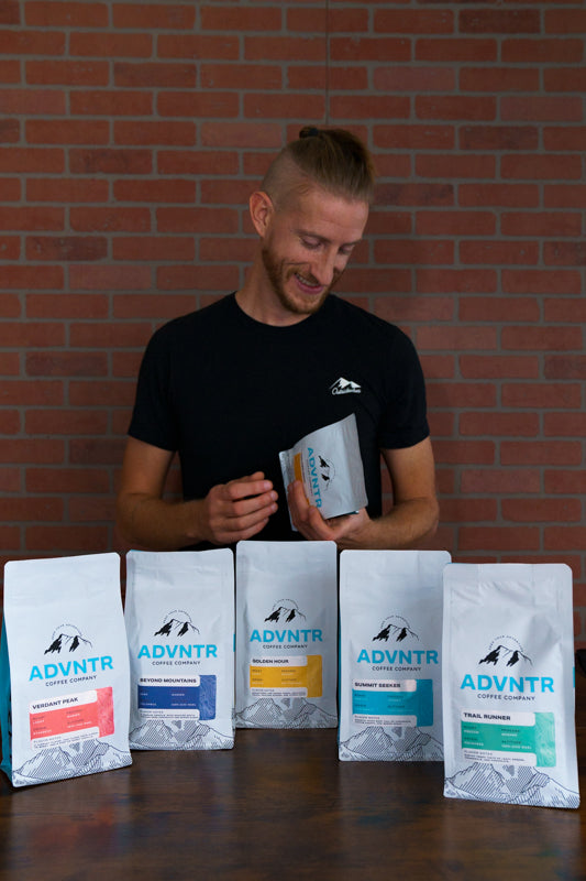 ADVNTR Coffee owner Sheridan smiling with our 12 ounce products