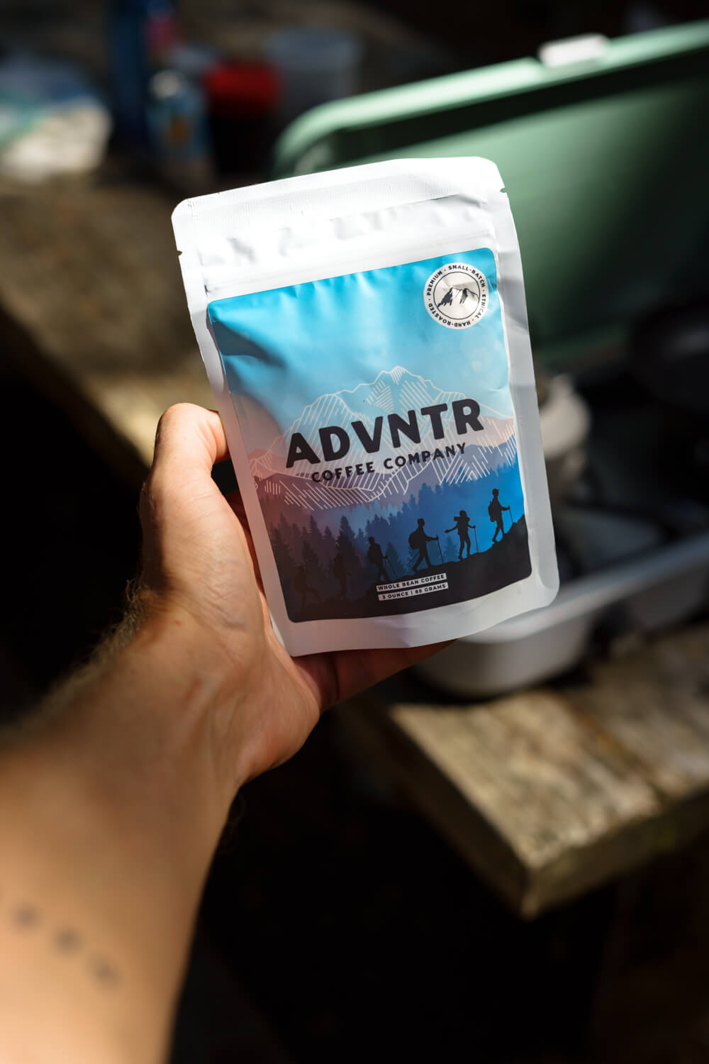 hand holding a 3 ounce coffee bag from adventure coffee roasters