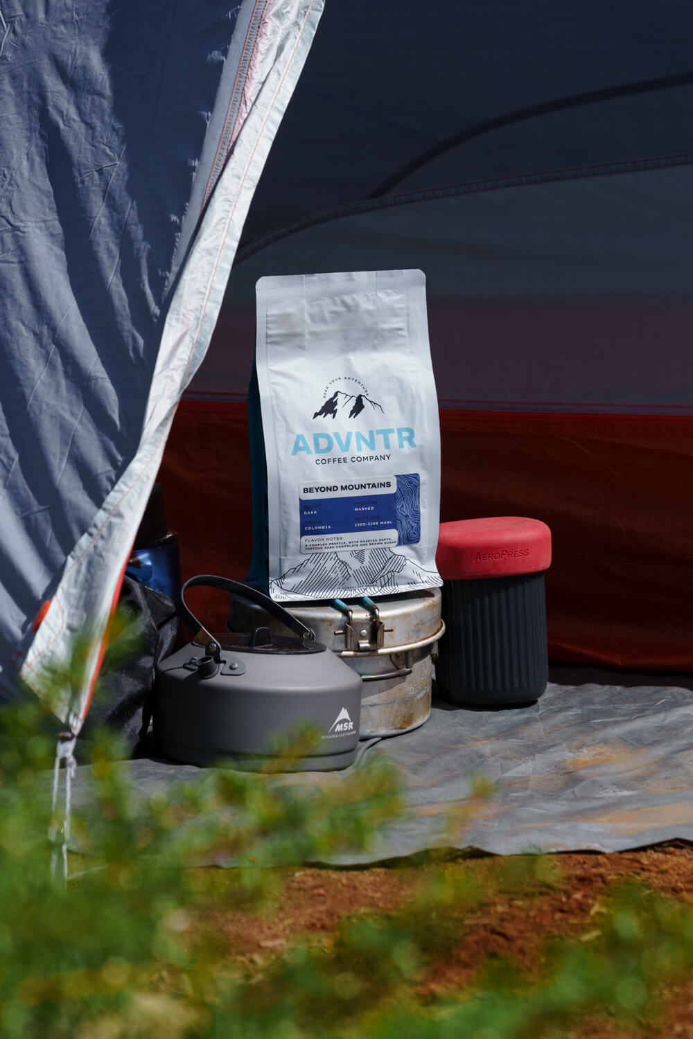 camping coffee setup with beyond mountains coffee bag aeropress msr kettle and tent