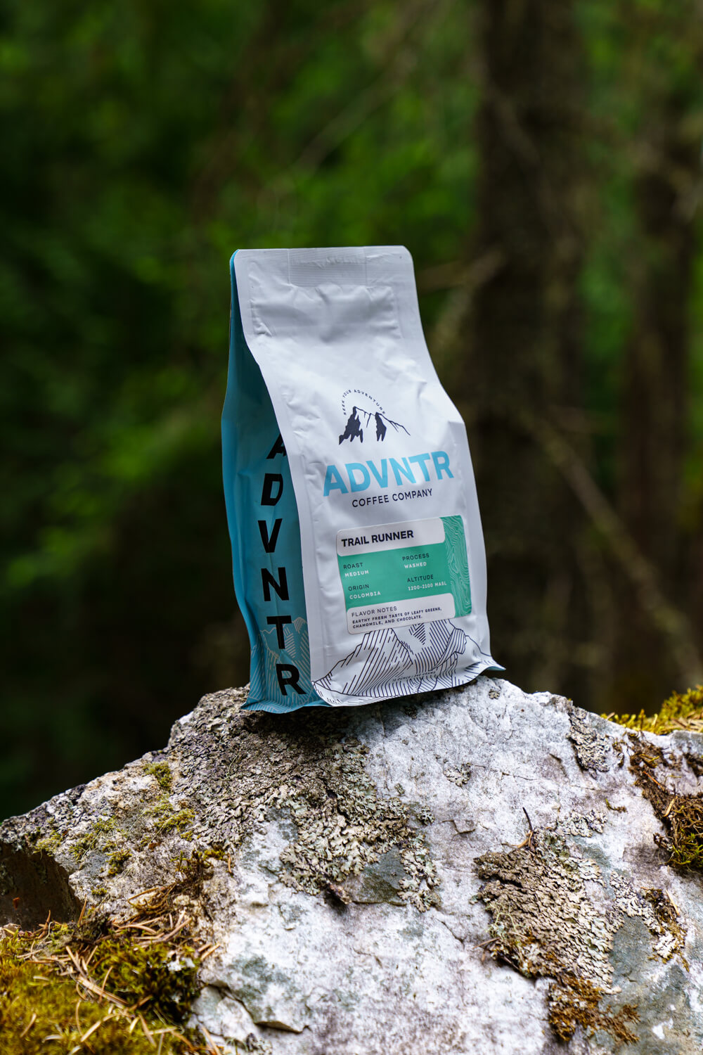 advntr coffee trail runner bag sitting on rock with pnw forest